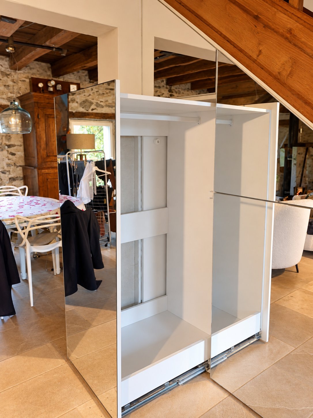 Penderie coulissante extractible dissimulée derrière une façade miroir